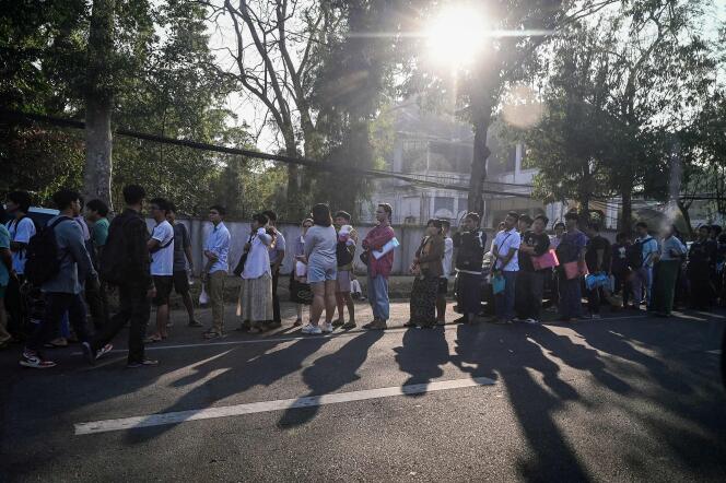 Le persone si mettono in fila per ottenere i visti presso l'ambasciata tailandese a Yangon, Myanmar, il 16 febbraio dopo che il governo militare ha annunciato la coscrizione.