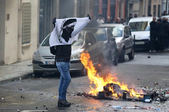 Un hombre blande una bandera corsa durante los enfrentamientos con la policía, el sábado 2 de marzo de 2024, en Bastia.