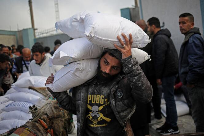Un palestino carga bolsas de ayuda humanitaria en el centro de distribución de la UNRWA en Rafah, sur de la Franja de Gaza, el 3 de marzo de 2024.