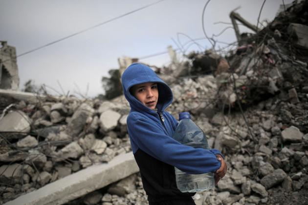 A Palestinian boy carries a bottle of water on a street in Rafah, March 3, 2024.