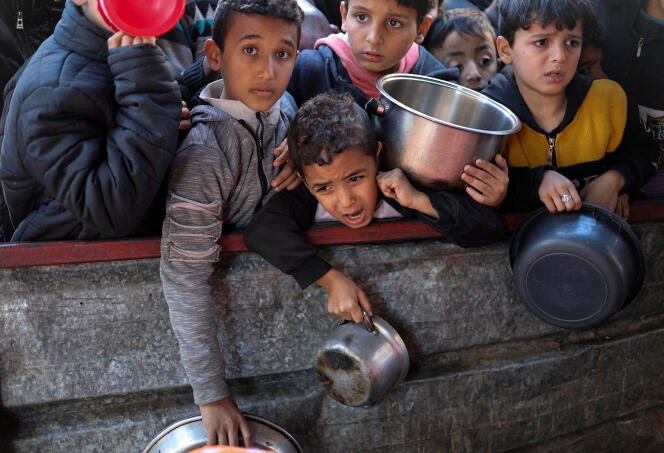 Des enfants palestiniens attendent de recevoir de la nourriture préparée par une cuisine caritative, alors que le conflit entre Israël et le groupe islamiste palestinien Hamas se poursuit, à Rafah, dans le sud de la bande de Gaza, le 5 février 2024. 