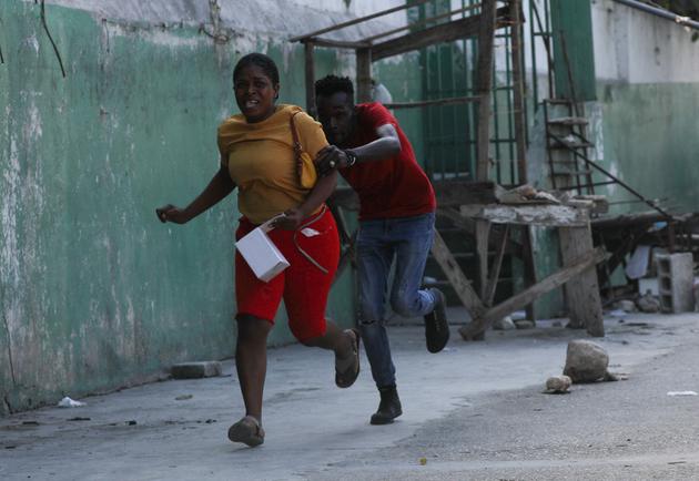 People running for cover during a firefight in Port-au-Prince, Haiti, March 1, 2024.