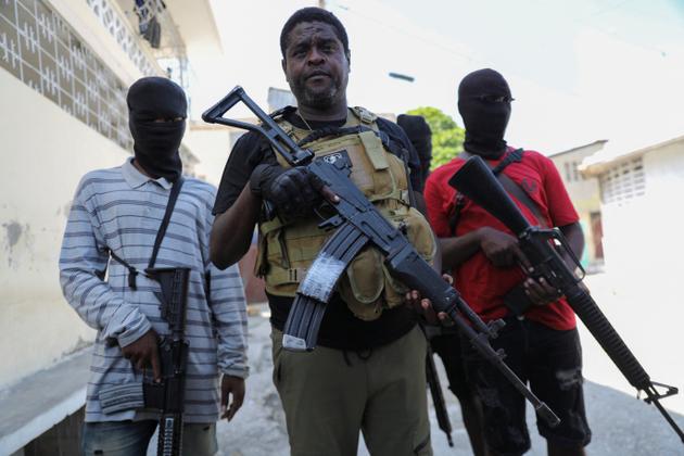 The leader of the G9 alliance of gangs, Jimmy "Barbecue" Chérizier, flanked by masked gunmen, in Port-au-Prince, Haiti, March 5, 2024.