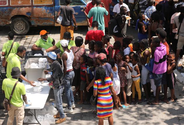 Residents who have fled violence gathering to receive meals, at a school being used as shelter as the government declared a state of emergency amid intense violence, in Port-au-Prince, Haiti, March 4, 2024. 