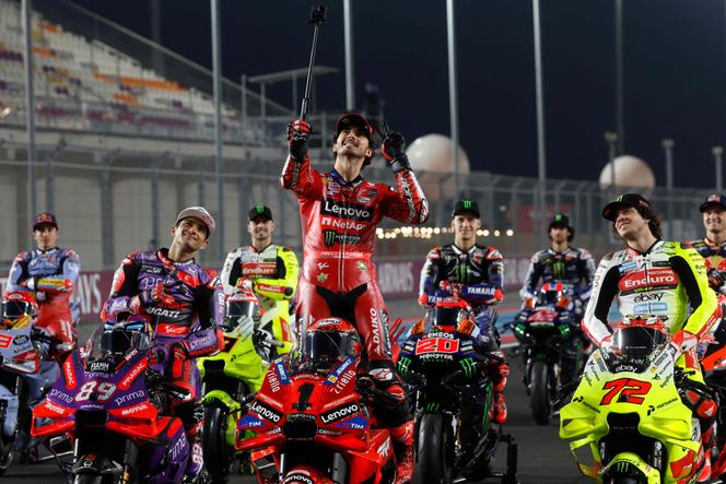L’Italien Francesco Bagnaia (Ducati) prend un selfie sur le circuit de Lusail, avant le Grand Prix du Qatar, à Doha, le 7&nbsp;mars 2024. A sa droite, l’Espagnol Jorge Martin, champion du monde 2024&nbsp;avec Pramac.