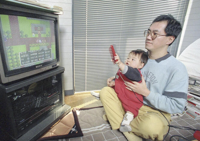 Akira Toriyama chez lui en train de jouer à un jeu vidéo avec son fils, à Kiyosu (Aichi), en 1988.