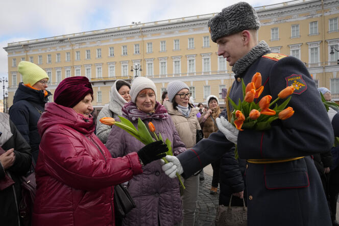 Un soldat de la garde d’honneur offre des fleurs à des femmes à l’occasion de la Journée internationale des droits des femmes à Saint-Pétersbourg, en Russie, le vendredi 8 mars 2024.