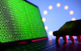 FILE PHOTO: A hand is seen on a laptop with binary codes displayed in front of the EU flag in this illustration taken, August 19, 2022. REUTERS/Dado Ruvic/Illustration/File Photo