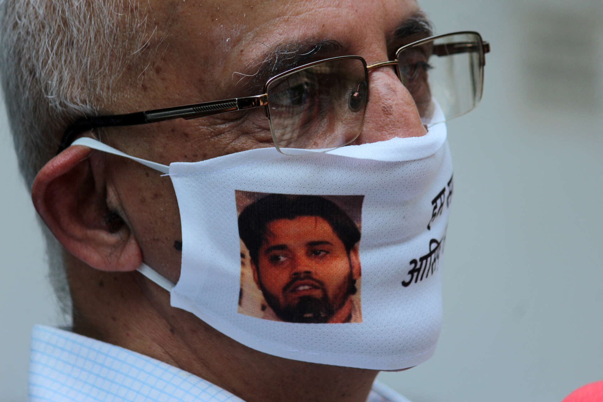 Harsh Mander, portant un masque à l’effigie d’un militant étudiant arrêté lors d’une conférence de presse, au Press Club of India, le 16 septembre 2020, à New Delhi.