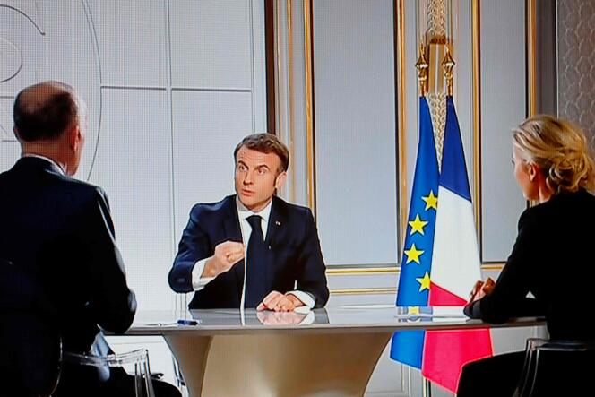 This photograph taken on March 14, 2024, shows a television screen broadcasting France's President Emmanuel Macron in a live interview on French TV channels TF1 and France 2 at the Elysée Presidential Palace in Paris. 