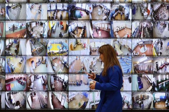 Des images de vidéosurveillance prises dans des bureaux de vote sont diffusées en direct, au siège de la commission électorale russe, à Moscou, le 16 mars 2024.