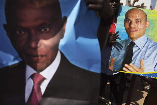 Simpatizantes del PDS sostienen fotografías de Abdoulaye y Karim Wade, en Dakar, en abril de 2013.