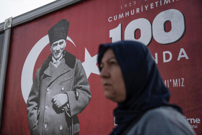 Une femme passe devant une bannière avec le portrait de Mustafa Kemal Ataturk avant les célébrations marquant le 100e anniversaire de la République turque à Edirne, marquant la fin du califat, dans l’ouest de la Turquie, le 25 octobre 2023.