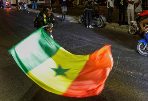 A supporter of Senegalese opposition leader Ousmane Sonko and the presidential candidate Bassirou Diomaye Faye, who were released from prison, holds Senegal's flag, after their press conference, in Dakar, Senegal March 15, 2024. REUTERS/Zohra Bensemra
