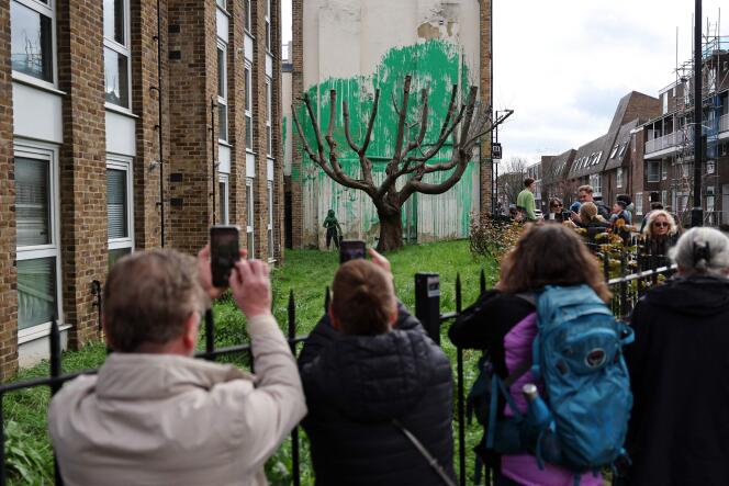 Crowds gather to view a Banksy artwork near Finsbury Park in north London on March 18, 2024.