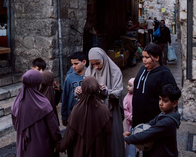 Young girls readjust their veils before going to the Al-Aqsa mosque for the evening "tarawih" prayer, in East Jerusalem, March 10, 2024.