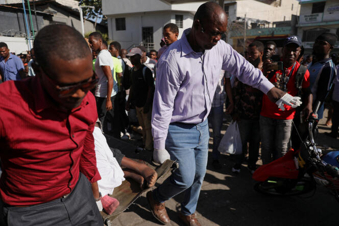 Empleados cargan el cuerpo de una persona que fue asesinada a tiros esa misma mañana, en Puerto Príncipe, Haití, el 18 de marzo de 2024.