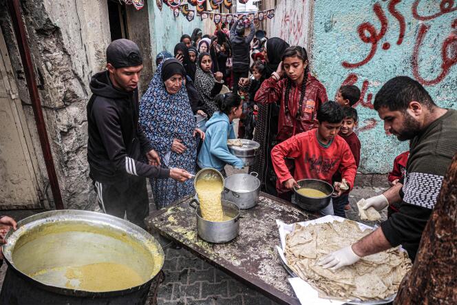 Des Palestiniens  font la queue pour recevoir de la nourriture donnée par une organisation caritative avant l’iftar, la rupture du jeûne, pendant le ramadan, à Rafah, dans le sud de la bande de Gaza, le 16 mars 2024.
