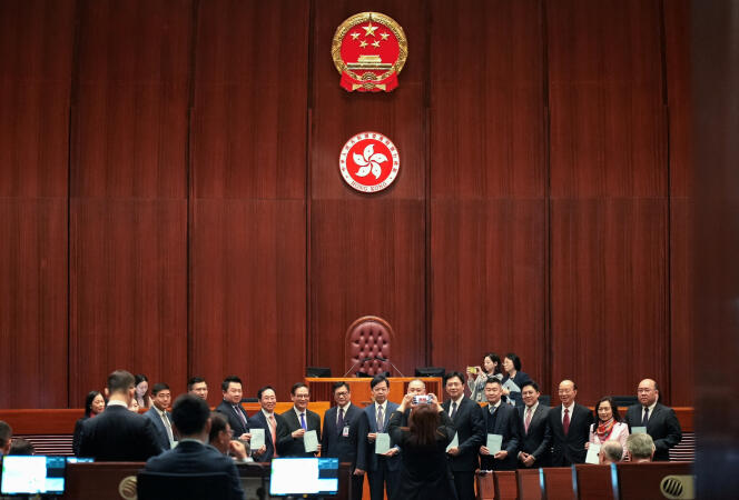 El ministro de Seguridad de Hong Kong, Chris Tang (centro), rodeado de miembros del LegCo, el Parlamento de Hong Kong, presenta el texto de la 