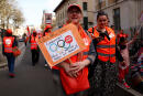 A protester holds a placard with the slogan "for a quality public service" and a CFDT labour union logo arranged with Olympic rings during a demonstration by French civil servants as part of a national day of strikes by public sector workers for better salaries and against reforms in the school system, in Paris, France, March 19, 2024. REUTERS/Gonzalo Fuentes