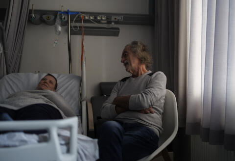 Carer and former doctor Denis Rousseaux talks with Lydie Imhoff (L) in a hospital room in Belgium, on February 1, 2024, as Imhoff waits for the doctor to arrive on the day of her euthanasia. Lydie Imhoff, a 43 year-old French citizen suffering from hemiplegia and blindness from birth due to a perinatal stroke, has been authorized to travel from Besancon, France, to Belgium to undergo euthanasia on February 1, 2024. (Photo by Simon Wohlfahrt / AFP) / SOLELY TO ILLUSTRATE THE EVENT AS SPECIFIED IN THE CAPTION – ANY USE IN ANOTHER CONTEXT WILL ENTAIL LIABILITY ON YOUR PART
