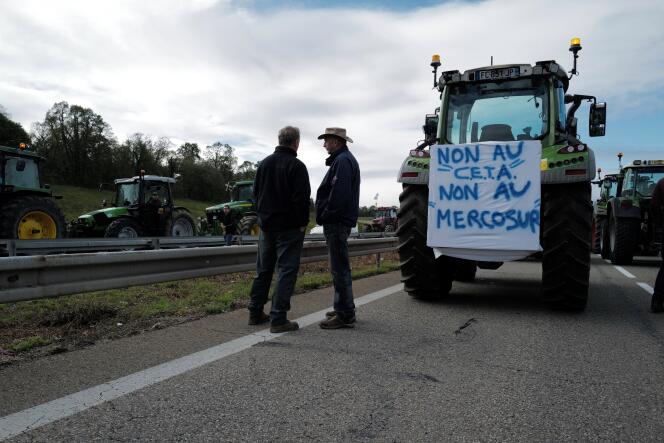 Des agriculteurs utilisent un tracteur orné d’une banderole pour bloquer la jonction des autoroutes A35 et A36 près de Mulhouse, dans l’est de la France, le 8 octobre 2019.