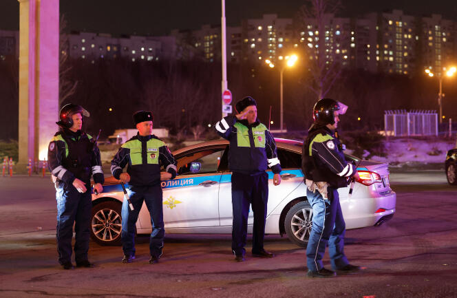 Russian law enforcement officers stand guard near the Crocus City Hall concert venue following a shooting, in a Moscow suburb, March 22, 2024. 