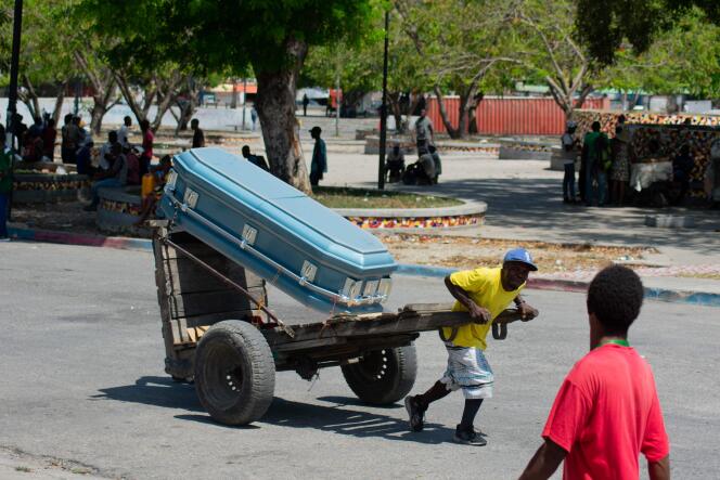 Un hombre tira de un carro sobre el que se coloca un ataúd, en una calle de Puerto Príncipe, el 22 de marzo de 2024.