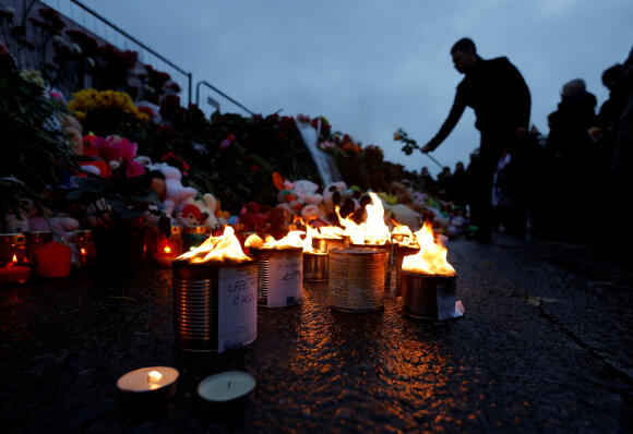 Un homme dépose des fleurs sur un mémorial improvisé en l’honneur des victimes de l’attentat, à l’extérieur du Crocus City Hall, en banlieue de Moscou, samedi 23 mars.