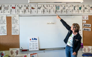 A teacher points to the letters of the alphabet on the first day of the start of the school year, at the Jules Ferry de la commune elementary school in Aytre, western France on September 2, 2019. In France some 12.4 million students crossed the doors of elementary schools (6.7 million), secondary school (3.4 million) and high schools (2.3 million) on September 2, 2019. (Photo by XAVIER LEOTY / AFP)