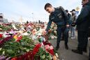 TOPSHOT - Russian Emergency Ministry cadets lay flowers at a makeshift memorial in front of the burnt-out Crocus City Hall concert venue in Krasnogorsk, outside Moscow, on March 26, 2024. At least 139 people were killed when gunmen in camouflage stormed Crocus City Hall, shooting spectators before setting the building on fire in the most fatal attack in Europe to have been claimed by Islamic State jihadists. (Photo by NATALIA KOLESNIKOVA / AFP)