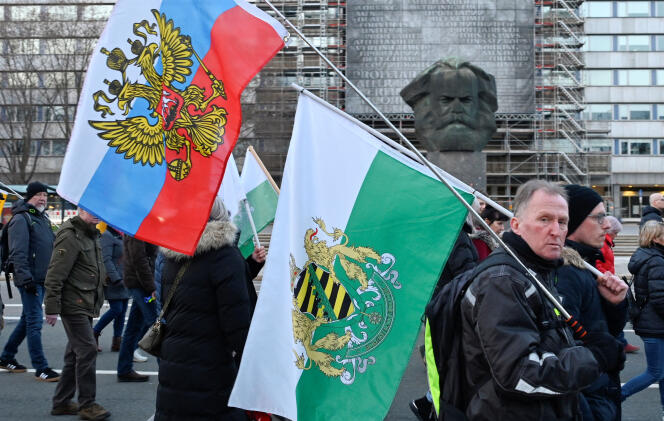 Un manifestant brandissant les drapeaux de la Russie et d’un mouvement d’extrême droite de Saxe lors d’une manifestation à Chemnitz, en Allemagne, le 18 mars 2024.