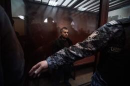 Dilovar Islomov suspected of taking part in the attack of a concert hall that killed 137 people, the deadliest attack in Europe to have been claimed by the Islamic State jihadist group, stands inside the defendant cage as he waits for his pre-trial detention hearing at the Basmanny District Court in Moscow on March 25, 2024. At least 137 people, including three children, were killed when camouflaged gunmen stormed the Crocus City Hall, in Moscow's northern suburb of Krasnogorsk, and then set fire to the building on March 22 evening. (Photo by TATYANA MAKEYEVA / AFP)