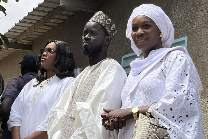 Bassirou Diomaye Faye entouré de ses épouses : Marie Khone Faye (à gauche) et Absa Faye (à droite), dans le village natal du nouveau président, à Ndiaganiao, le 24 mars 2024.