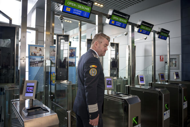 A police officer stands in front of Non-Schengen automatic border control gates, at the Henri Coanda International Airport in Otopeni, near Bucharest, Romania, Thursday, March 28, 2024.