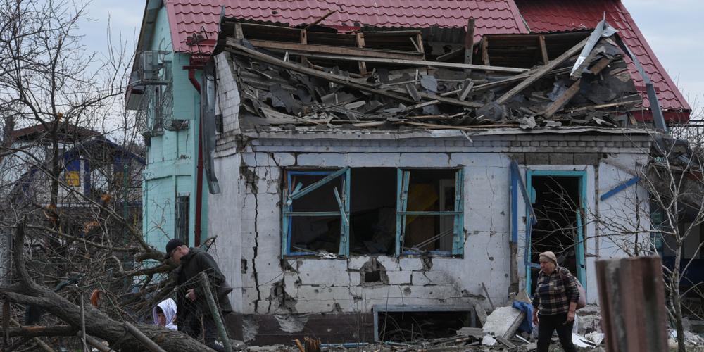 Des habitants à côté de leur maison endommagée par une attaque de missiles et de drones russes, à Kamianske, dans la région de Dnipropetrovsk, le 29 mars 2024.