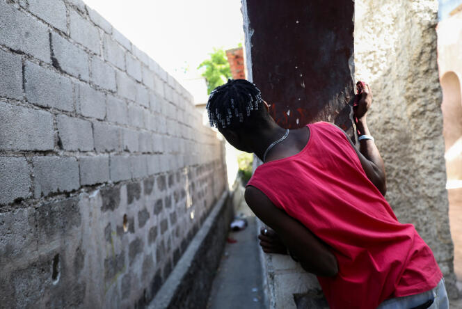 Un homme regarde un cadavre, alors que des gangs rivaux se battent pour le contrôle du territoire et que l'État reste largement absent, à Port-au-Prince, Haïti, le 1er avril 2024. 