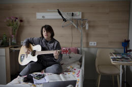 Olga Chudna, blessée sur le front, joue de la guitare dans sa chambre au centre de réhabilitation « Recovery », à Kiev, le 12 mars 2024. Olga retournera prochainement chez elle.