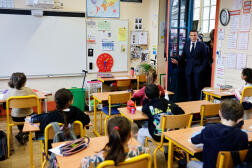 Le président français Emmanuel Macron entre dans une classe de CE2 à l’école primaire Blanche, à Paris, le 5 avril 2024. 