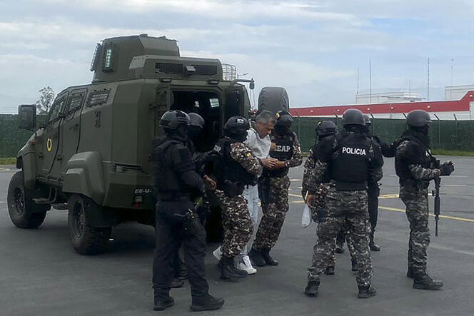 Cette photo publiée par la police équatorienne montre l'ancien vice-président équatorien Jorge Glas (au centre) escorté par des policiers avant son transfert à la prison de haute sécurité de Guayaquil, à l'aéroport international de Quito, le 6 avril 2024.
