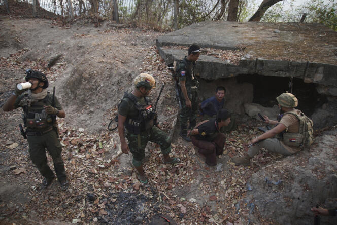 Members of the Karen National Liberation Army and the People's Defense Force examine two captured soldiers after capturing a military outpost, April 11, 2024, in Myawaddy, Burma.
