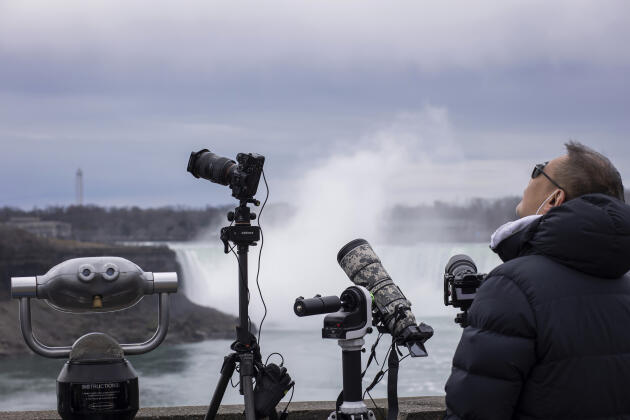 Des spectateurs ont installé leurs appareils photo pour photographier l'éclipse totale de Soleil près des chutes du Niagara, en Ontario, le 8 avril 2024.