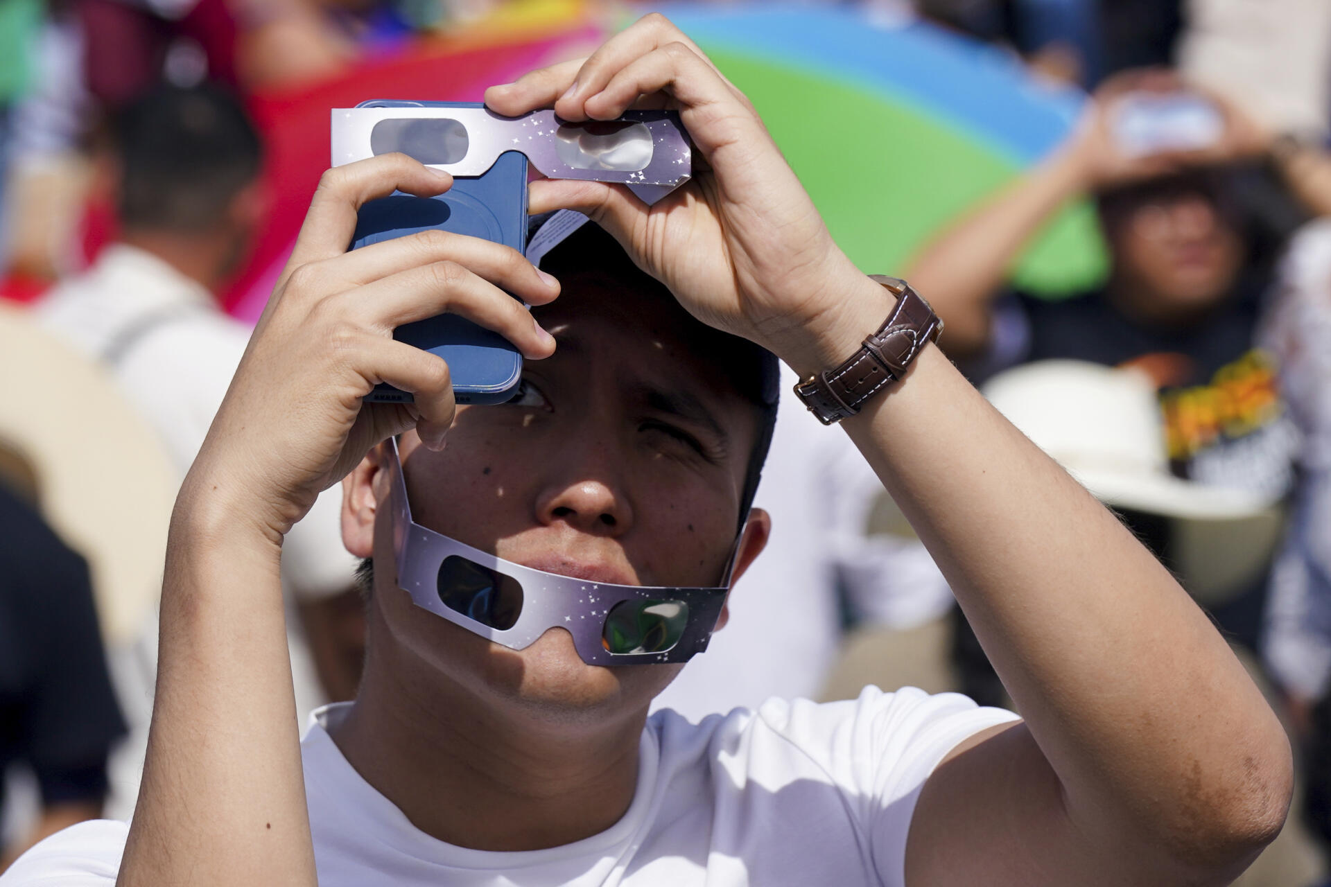 Un adolescent utilise son téléphone pour prendre une photo de l'éclipse totale de Soleil, à Mazatlan, au Mexique, le 8 avril 2024.