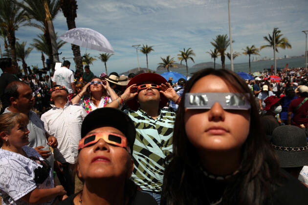 Des spectateurs regardent une éclipse totale de Soleil portant des lunettes de protection spéciales à Mazatlan, au Mexique, le 8 avril 2024.