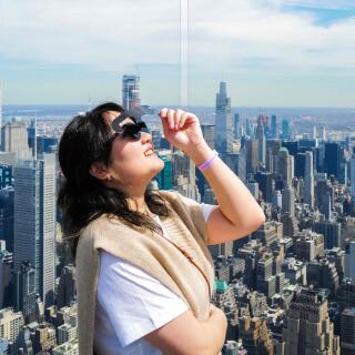 A woman looks toward the sky at the 'Edge at Hudson Yards' observation deck ahead of a total solar eclipse across North America, in New York City on April 8, 2024. This year's path of totality is 115 miles (185 kilometers) wide and home to nearly 32 million Americans, with an additional 150 million living less than 200 miles from the strip. The next total solar eclipse that can be seen from a large part of North America won't come around until 2044.
 (Photo by Charly TRIBALLEAU / AFP)