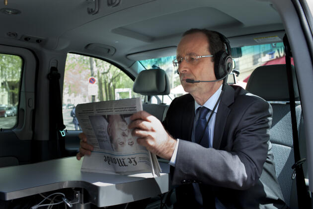François Hollande reads Le Monde as he waits for the start of an interview, inside a radio truck in front of his campaign HQ, in Paris, April 11, 2012.