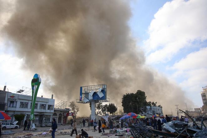 Des Palestiniens regardent la fumée s'échapper d'un bombardement israélien sur le marché de Firas, dans la ville de Gaza, le 11 avril 2024.