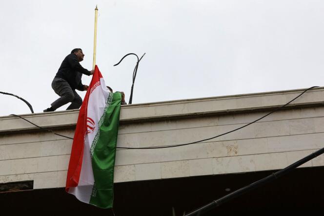 Un membre du personnel installe le drapeau iranien au sommet de la nouvelle annexe consulaire de l’ambassade d’Iran à Damas, le jour de son inauguration, le 8 avril 2024.