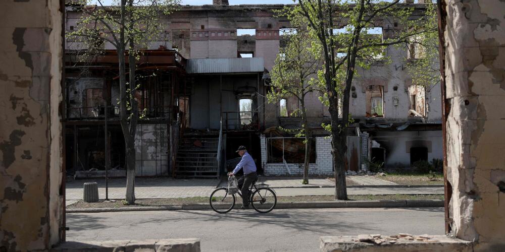 Un homme à vélo dans une rue aux bâtiments détruits de la ville de Lyman, dans la région de Donetsk, le 13 avril 2024.