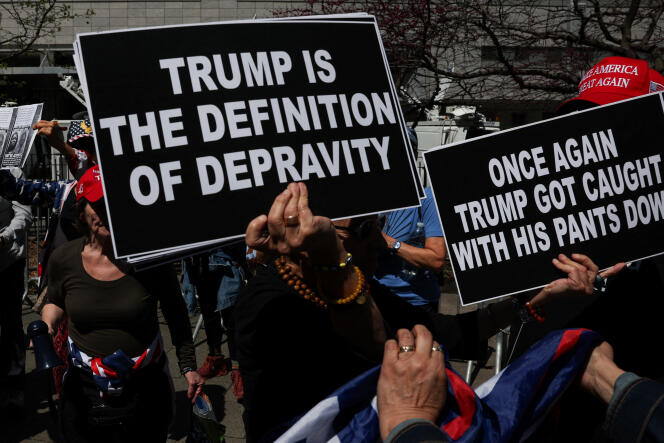 Des manifestants anti-Trump brandissent des pancartes devant le palais de justice de New York le jour du début du procès de l'ex-président, le 15 avril 2024. 